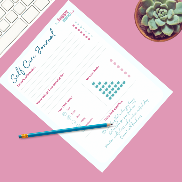 Self Care checklist on desk with a pencil on top of it next to a plant and a keyboard