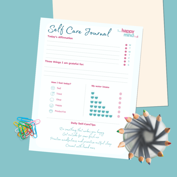 Self Care Journal on desk with pencils and paperclips