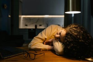 Winrers affect on our mental health - woman tired lying on desk in a dimly lit room